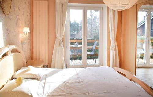 a bedroom with a white bed and a large window at Villa Pascale in Robertville