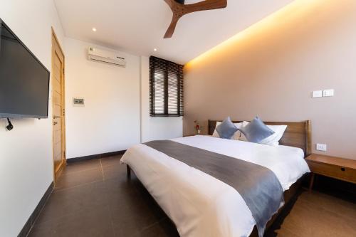 a bedroom with a large bed and a flat screen tv at Phuoc Linh Homestay in An Bang