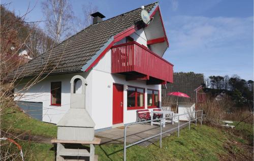 a small white and red house with a deck at Ferienhaus 44 In Kirchheim in Kemmerode
