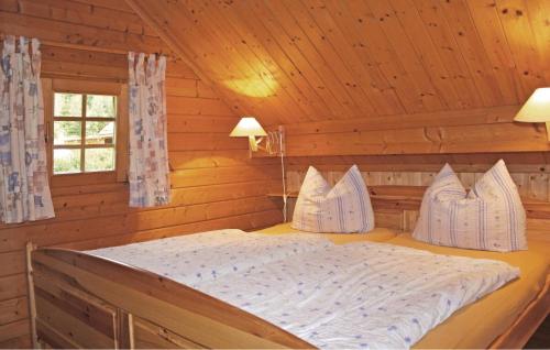 um quarto com uma cama num chalé de madeira em Am Thringer Meer em Drognitz