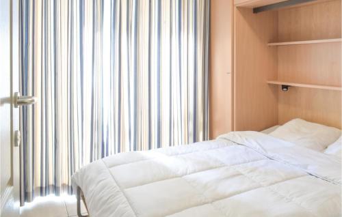 ein Schlafzimmer mit einem weißen Bett und einem großen Fenster in der Unterkunft Residentie Zeezicht in Ostende