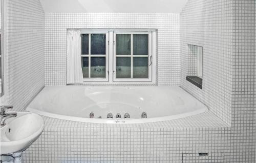 La salle de bains blanche est pourvue d'une baignoire et d'un lavabo. dans l'établissement Awesome Home In Gl With Sauna, à Gålå