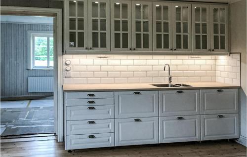 a kitchen with white cabinets and a sink at Gorgeous Home In Bodafors With Kitchen in Bodafors