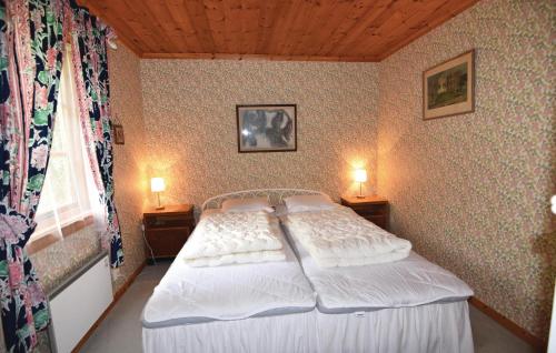 a bedroom with a bed with two lamps on two tables at 2 Bedroom Cozy Home In Sjötorp in Sjötorp