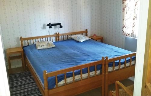 a bedroom with a wooden bed with a blue comforter at 3 Bedroom Awesome Home In Srna in Särna