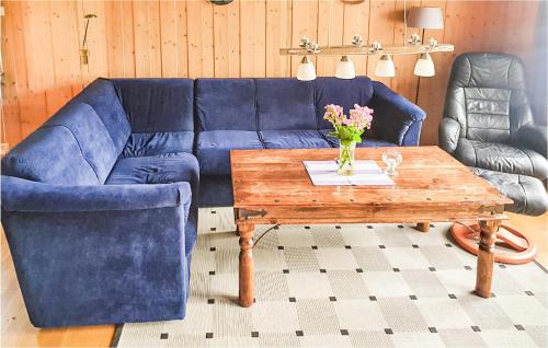 a living room with a blue couch and a wooden table at Trollstua in Asak