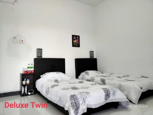 two beds sitting next to each other in a room at Aleesa Roomstay & Hotel in Pasir Puteh