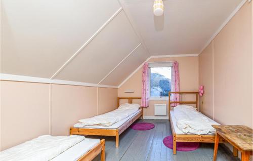 Habitación con 2 camas y mesa. en Nice Home In Gjra With 2 Bedrooms And Wifi, en Musgjerd