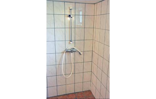 y baño alicatado con ducha y manguera. en Cozy Home In Odensvi With Kitchen en Stora Skälhem