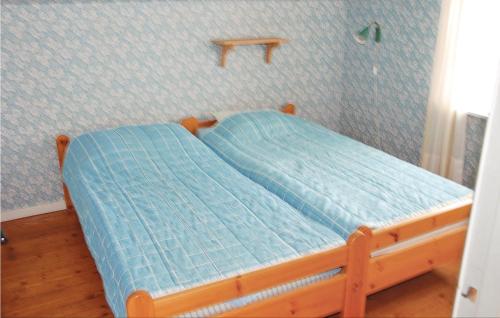 1 dormitorio con 1 cama con edredón azul en Cozy Home In Odensvi With Kitchen en Stora Skälhem