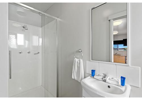a bathroom with a shower and a sink and a mirror at Discovery Parks - Mackay in Mackay