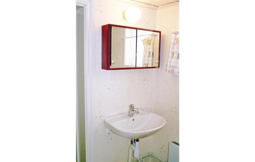 La salle de bains est pourvue d'un lavabo et d'un miroir mural. dans l'établissement Beautiful Home In Linneryd With Kitchen, à Linneryd