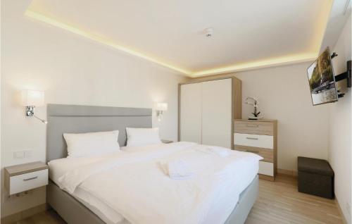 een slaapkamer met een groot wit bed en een dressoir bij Garden Suite in Binz