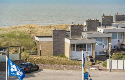 a car parked in front of a house next to the ocean at De Trapjes in Bergen aan Zee