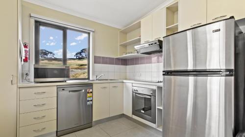 uma cozinha com um frigorífico de aço inoxidável e uma janela em Higgi Drive 4 em Mount Hotham