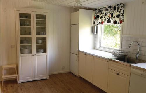 a kitchen with white cabinets and a sink and a window at 2 Bedroom Stunning Home In rkelljunga in Fasalt