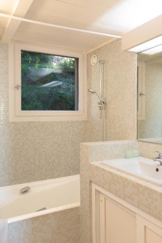 une salle de bain avec une baignoire, un lavabo et une fenêtre dans l'établissement AMAZING SEA VIEW APARTMENT with Private Close Parking, à Saint-Jean-Cap-Ferrat