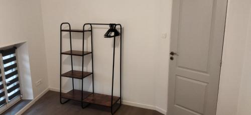 une étagère dans une pièce avec une lampe à côté d'une porte dans l'établissement Appartement en duplex à Hébuterne, avec lave linge, à Hébuterne