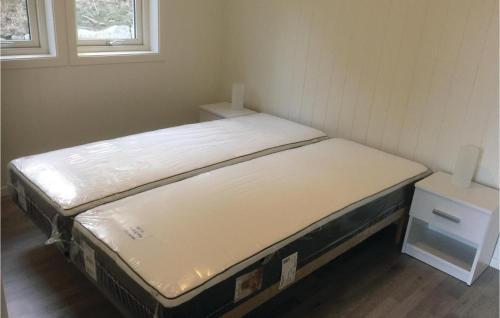 Bett in einem kleinen Zimmer mit zwei Fenstern in der Unterkunft Beautiful Home In Lyngdal With Kitchen in Lyngdal