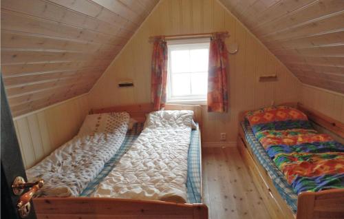 two beds in a small room with a window at Havtunet in Trolldalen