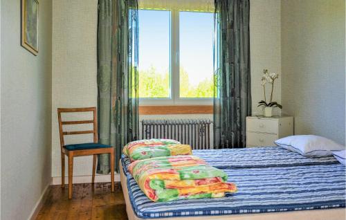 a bedroom with a bed and a chair and a window at 4 Bedroom Stunning Home In Mariannelund in Mariannelund