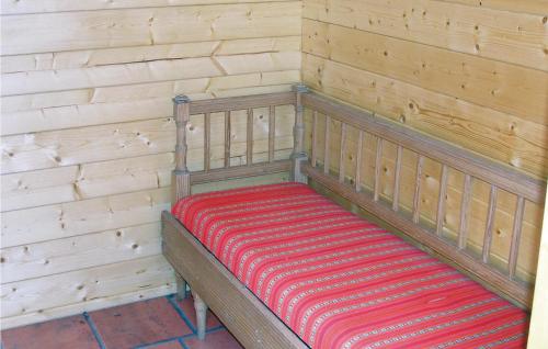 a wooden bench with a red and white striped blanket at Stunning Home In Stde With Kitchen in Stor-Hullsjön