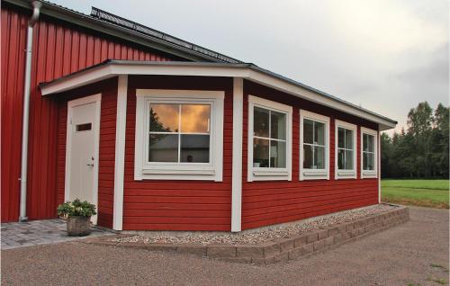 a red house with a white window on the side of it at 2 Bedroom Lovely Apartment In Habo in Mullsjö