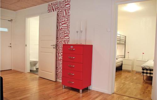 a red dresser in a room with a bedroom at 2 Bedroom Cozy Apartment In Habo in Mullsjö