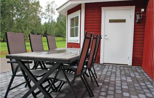 un tavolo e sedie su un patio con una casa di 2 Bedroom Lovely Apartment In Habo a Mullsjö