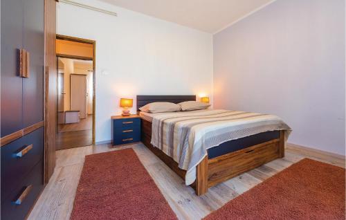 a bedroom with a bed with two lamps and a mirror at Awesome Home In Sibenik With Wifi in Šibenik