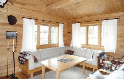 a living room with a couch and a table at Cozy Home In Rendalen With Sauna in Akrestrommen