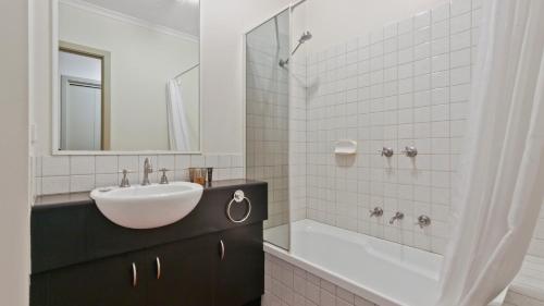 ein weißes Badezimmer mit einem Waschbecken und einer Badewanne in der Unterkunft Karoondah 10 in Mount Hotham