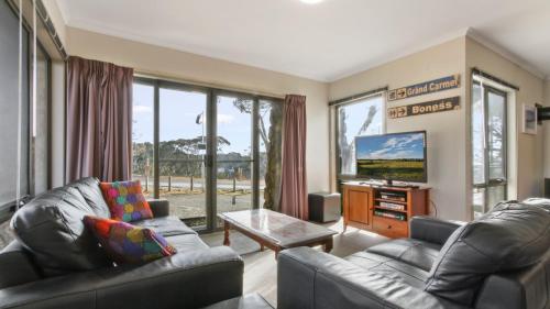 a living room with two couches and a tv at Karoondah 10 in Mount Hotham