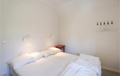 a white bed with two pillows in a room at Holiday Home Hangvar Gullauser Lärbro in Ire