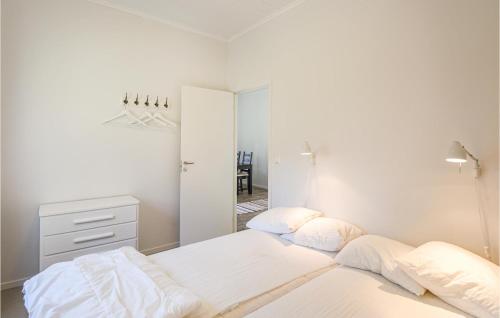 a white bedroom with two beds and a mirror at Holiday Home Hangvar Gullauser Lärbro in Ire