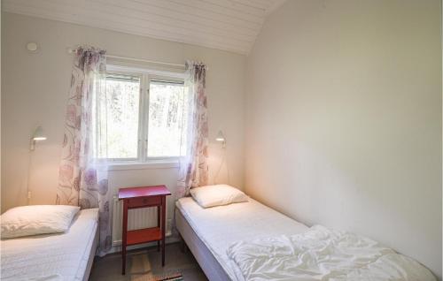 two beds in a small room with a window at Holiday Home Hangvar Gullauser Lärbro in Ire