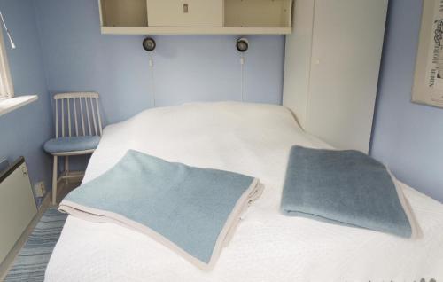 um pequeno quarto com 2 camas e uma cadeira em 1 Bedroom Lovely Home In Oskarstrm em Årnilt