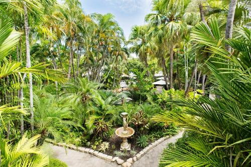 a garden with palm trees and a fountain at Seahaven Resort in Townsville