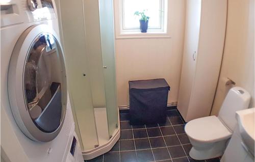 a bathroom with a washing machine and a window at Lovely Home In rjng With House Sea View in Östra Viker