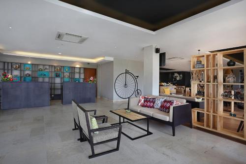 a living room with a couch and a table at Azana Boutique Hotel Denpasar in Denpasar