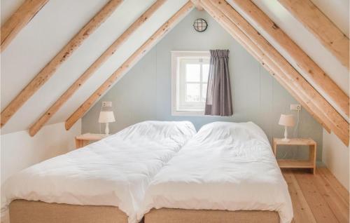 una camera da letto con letto bianco in mansarda di Het Vissershuisje a Wijdenes