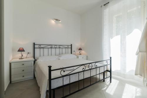 a white bedroom with a bed and a window at Gurosai in Dorgali