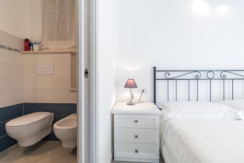 a bedroom with a bed and a toilet and a sink at Gurosai in Dorgali