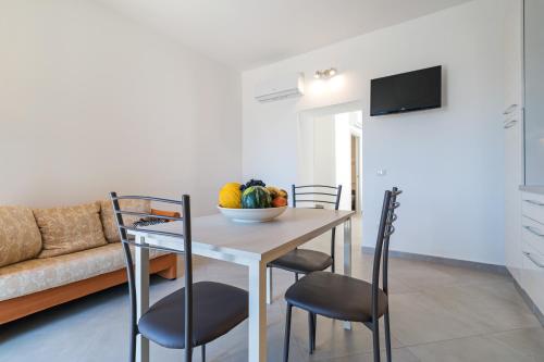 a kitchen and dining room with a table and chairs at Gurosai in Dorgali