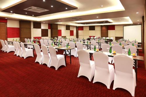 a conference room with tables and white chairs at Azana Boutique Hotel Denpasar in Denpasar