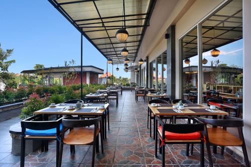 a restaurant with tables and chairs on a patio at Azana Boutique Hotel Denpasar in Denpasar