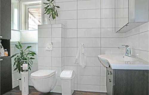 Baño blanco con aseo y lavamanos en 4 Bedroom Awesome Home In Farsund en Herad