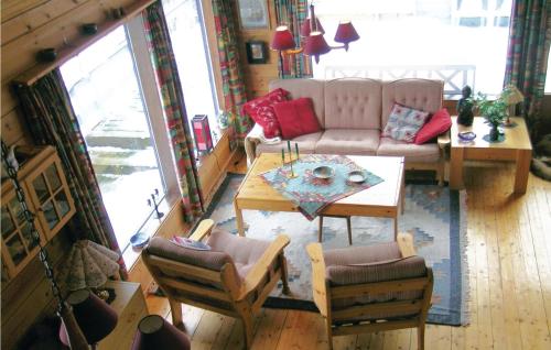 a living room with a couch and a table and chairs at Holiday Home Lyngdal Lindelia in Osestad