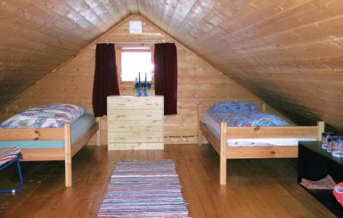 OsestadにあるAmazing Home In Lyngdal With 3 Bedroomsのベッドルーム(ベッド2台付)が備わる屋根裏部屋です。