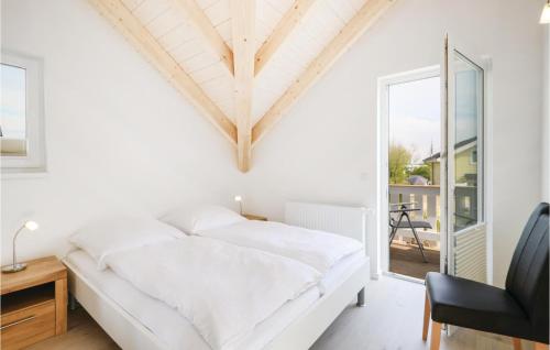 ein weißes Schlafzimmer mit einem Bett und einem Schreibtisch in der Unterkunft Seerose 5 in Süssau